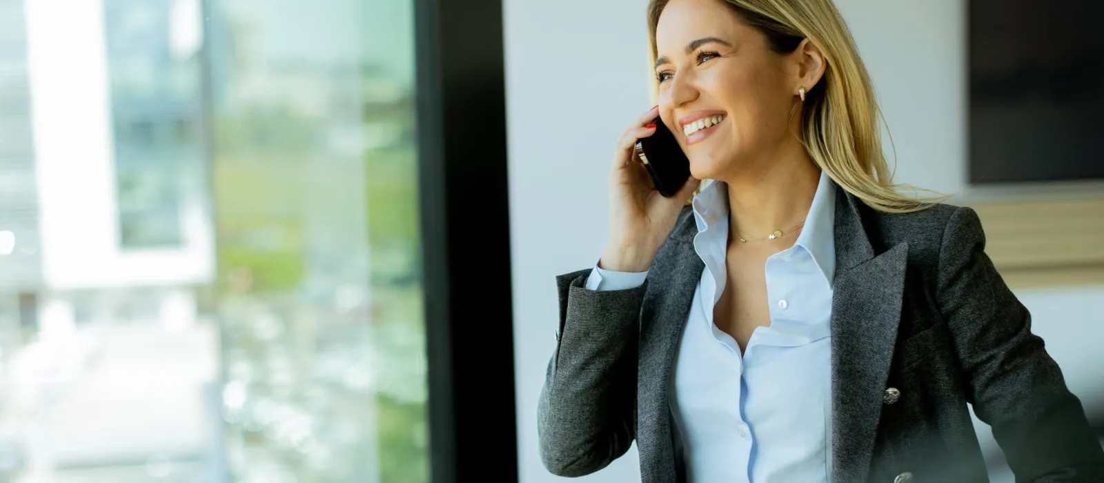 Frau, die im Büro mit ihrem Handy telefoniert